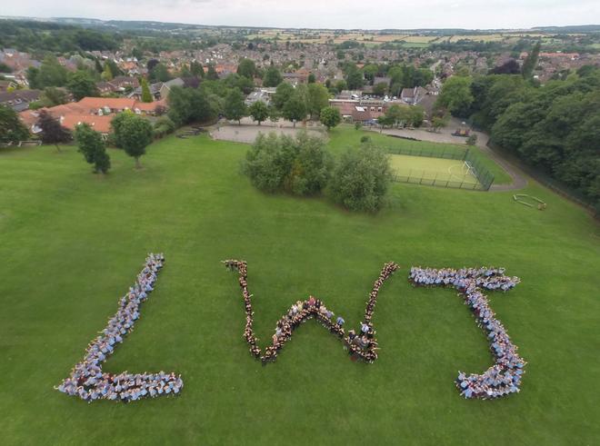 aerial shot of school field with students lined up to spell LWJ