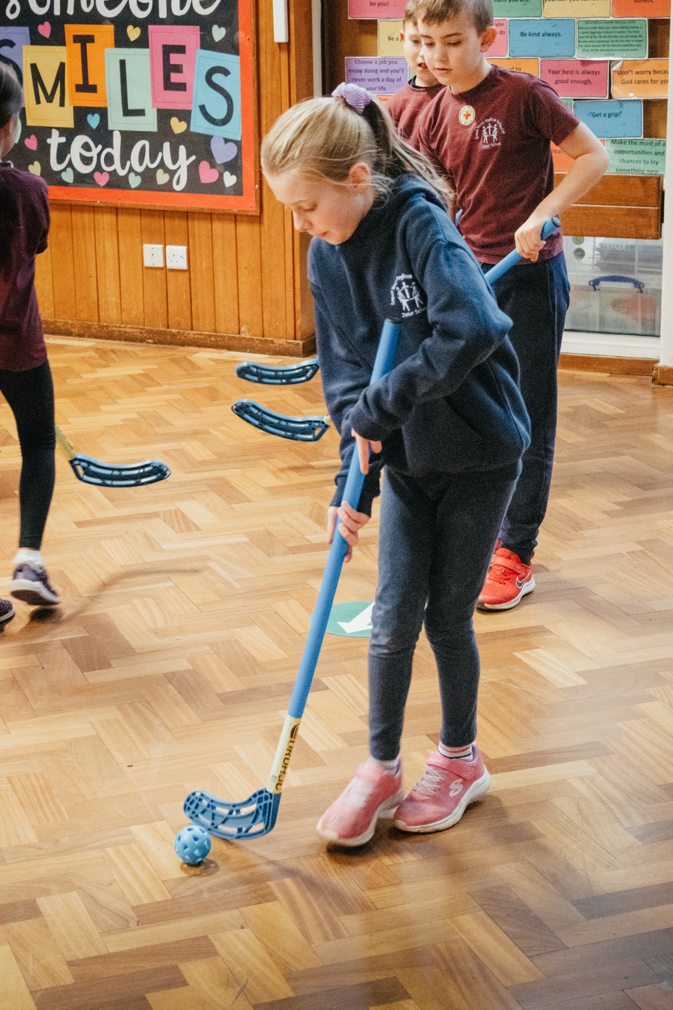 student playing hockey in school hall