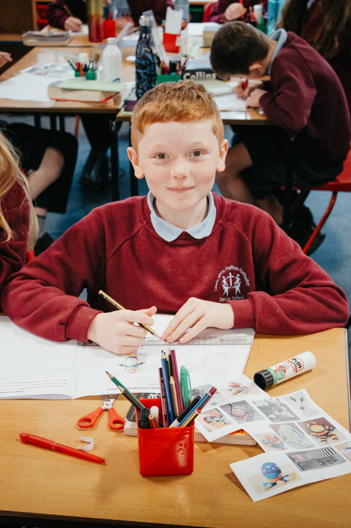 student working in book smiling to camera