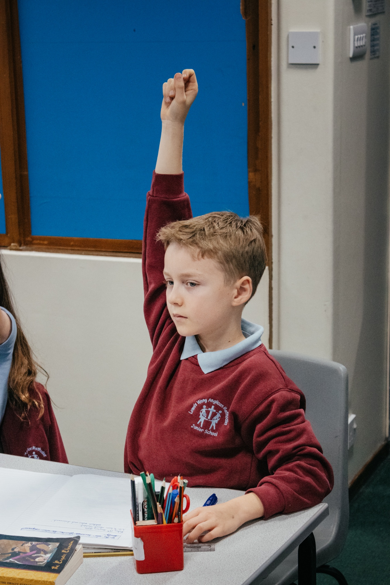 student with hand up